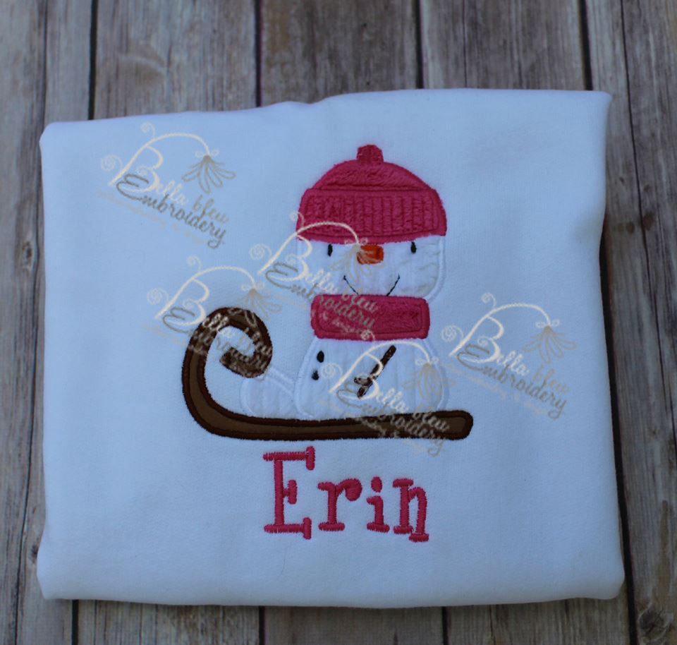Snowman riding a sled